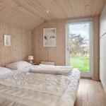 Bedroom with wooden walls, bed, and view of green areas
