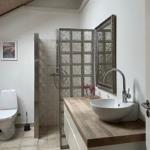 Bathroom with shower, sink and toilet under sloped ceiling