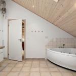 Bathroom with bathtub, sink, and wooden ceiling