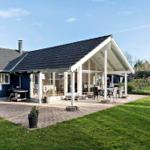 House with terrace, garden, and grill area. Glass veranda with seating.