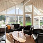 Living room with black leather furniture and large window view of garden