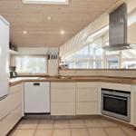 Kitchen with wooden ceiling, windows, and modern appliances.