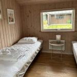 Two single beds, wooden walls, window with view of garden.