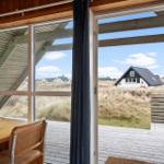 Durch große Fenster Blick auf Dachgaube und Ferienhaus im Grasland.