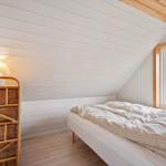 Schlafzimmer mit Bett, Fenster und Holzwand