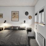 Bedroom with bed, wall art, and windows.