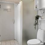 Bathroom with toilet, sink, and shower with curtain.