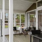 Deck with table, chairs, and view of green areas.