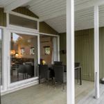 Deck with table and chairs, large sliding glass doors to interior.