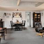 Living and dining area with fireplace, dining table, and leather armchair.