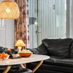 Black leather sofas around a round table with fruit and popcorn.