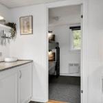Kitchen with countertop and view into bedroom with bunk bed.