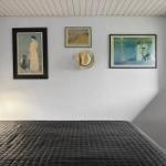 Bedroom with bed, wall art, and window.