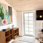 Raum mit Holzdecke, Fernseher, Tür und Wandbild.