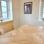 Esszimmer mit Holztisch, Stühlen und Fenstern