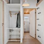 Flur mit Garderobe, Tür und Bad. Wand mit Handgriffen.