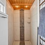 Dusche mit Holzdecke, Fliesenwand und Handtuchhalter