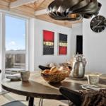 Runder Tisch mit Stühlen, Wanduhr und Fenster zum Balkon