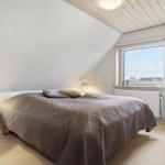 Schlafzimmer mit Bett, Fenster und Holzdecke.
