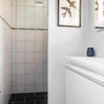Badezimmer mit Dusche, Waschbecken und Heizkörper