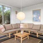 Wohnbereich mit Sofa, Tisch und großen Fenstern.