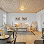 Wohnraum mit Esstisch, Sofa, Kaminofen und Holzdecke.