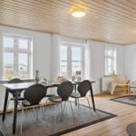 Esszimmer mit Tisch und Stühlen, Wohnbereich mit Sofa und Fenstern