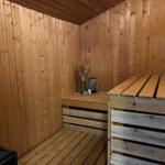 Sauna with wooden walls, benches, and decorative items.