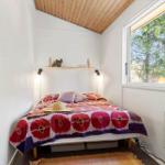 Bedroom with bed, window, and mirror on the wall.