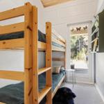Room with wooden bunk bed and view of terrace.