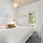 Bedroom with bed, striped wall, and door to garden.