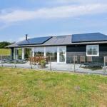 Moderne Villa mit Solaranlage und großem Außenbereich mit Sitzgelegenheiten.
