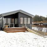 Moderne Villa mit Holzterrasse und Schneebedecktem Grundstück.