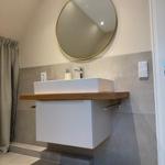 Bad mit Waschbecken, Spiegel und Duschvorhang