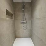 Duschkabine mit Duschbrause und eingebauter Ablage