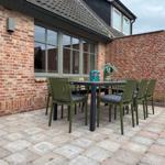 Terrasse mit Tisch und Stühlen vor Backsteinhaus