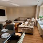 Wohn- und Essbereich mit Sofa, Esstisch und TV.