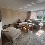 Wohnzimmer mit Sofa, Couchtisch und Fernseher an der Wand.