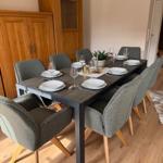 Esszimmer mit Tisch, sechs Stühlen und Holzmöbeln.