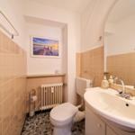 Badezimmer mit Toilette, Waschbecken und Wandbild.