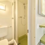 Badezimmer mit Dusche, Toilette und Waschbecken.