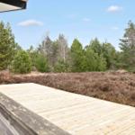 Holzterrasse mit Blick auf Wald und Heide.