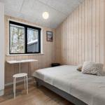 Schlafzimmer mit Bett, Schreibtisch und Fenster zur Aussicht.