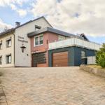 Haus Bergfried mit Garage und Balkon. Pflasterplatz vor dem Eingang.
