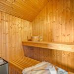 Sauna mit Holzwand, Sitzbank, Holzregal und Steinmulde.