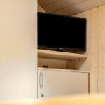 Fernseher in eingebauter Nische mit Holzwand und Schränken