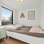 Schlafzimmer mit Bett, Fenster und Nachttisch.