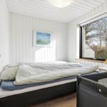 Schlafzimmer mit Bett, Fenster und Kinderbett.