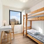 Zimmer mit Doppelstockbett, Schreibtisch und Fenster mit Blick.