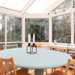 Round table with chairs in a spacious room with large windows.